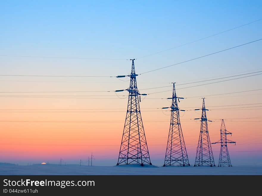 Electrical mast morning snow sunrise voltage cables. Electrical mast morning snow sunrise voltage cables