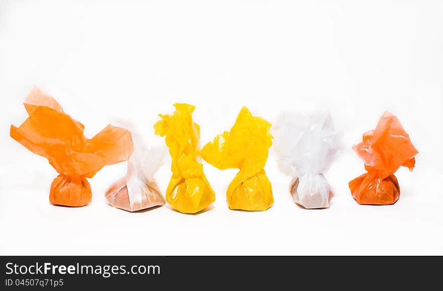 Toffees in many-coloured wrappers on white background