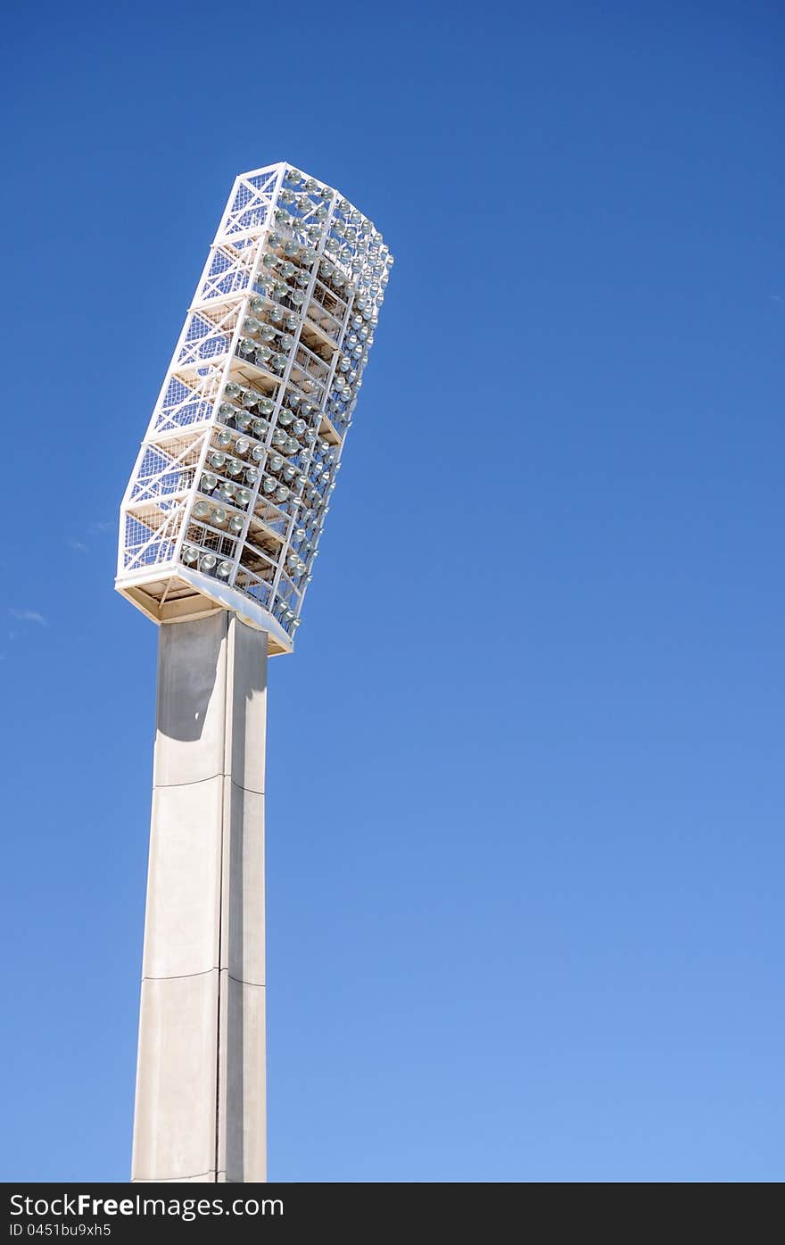 White floodlights found in sports arenas against blue sky background