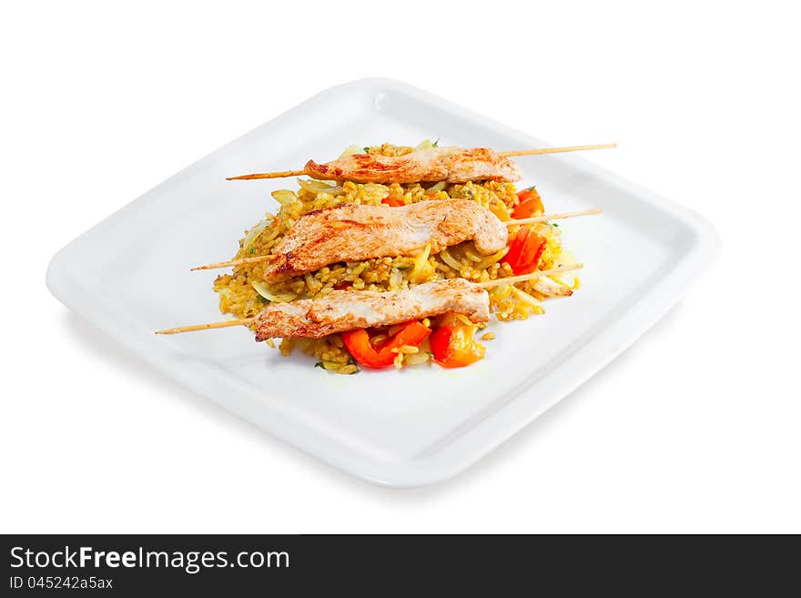 Kebab with rice and vegetables on a white background