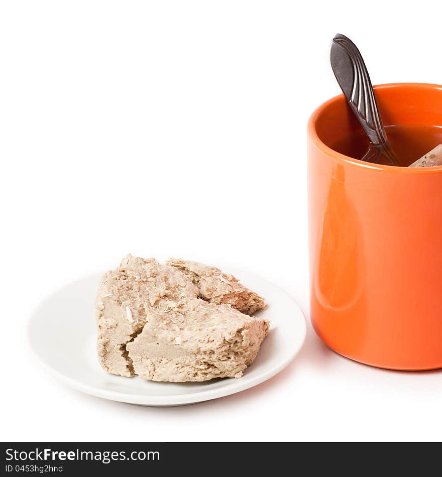 Orange cup of tea and halva on plate