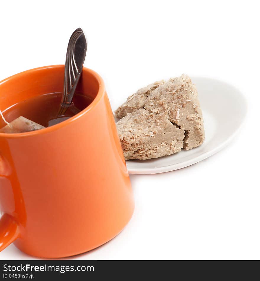 Orange cup of tea and halva on plate