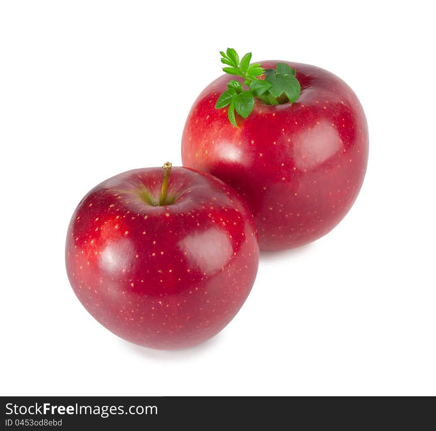 The red juicy apples with leaf isolated on white