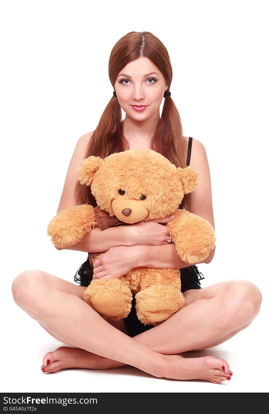 Cute young sexy girl in black underwear with a teddy bear over white background. Cute young sexy girl in black underwear with a teddy bear over white background