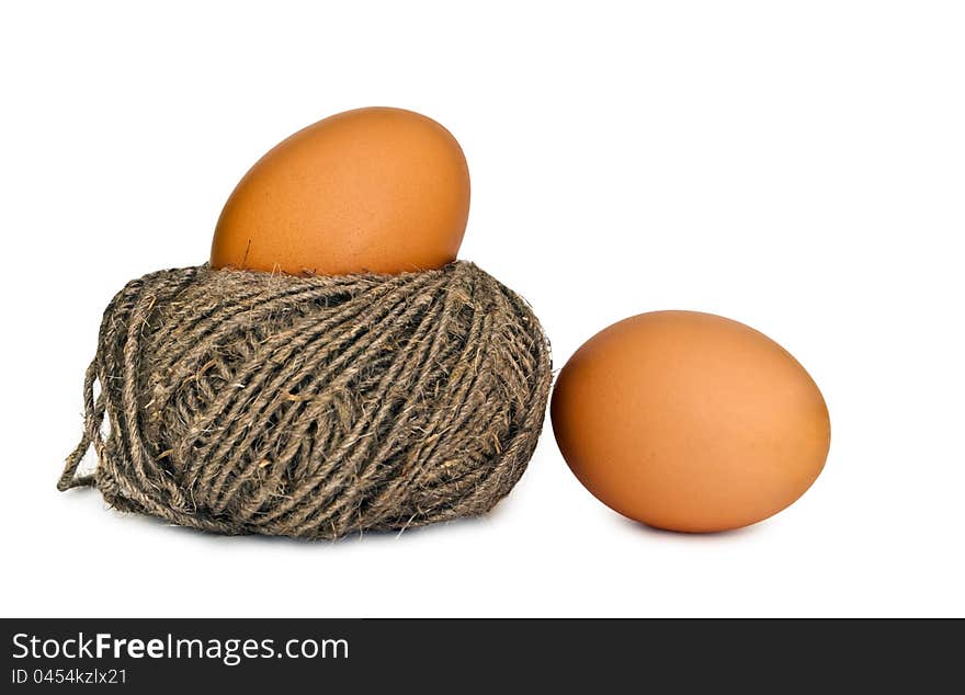 Two eggs on the white background, one of eggs lies in a nest