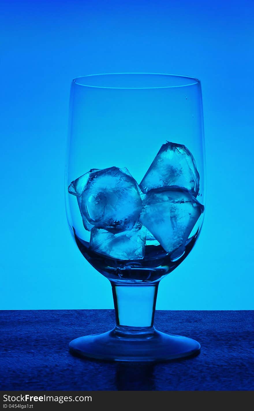 Glass for wine with ice crystals on a dark blue background