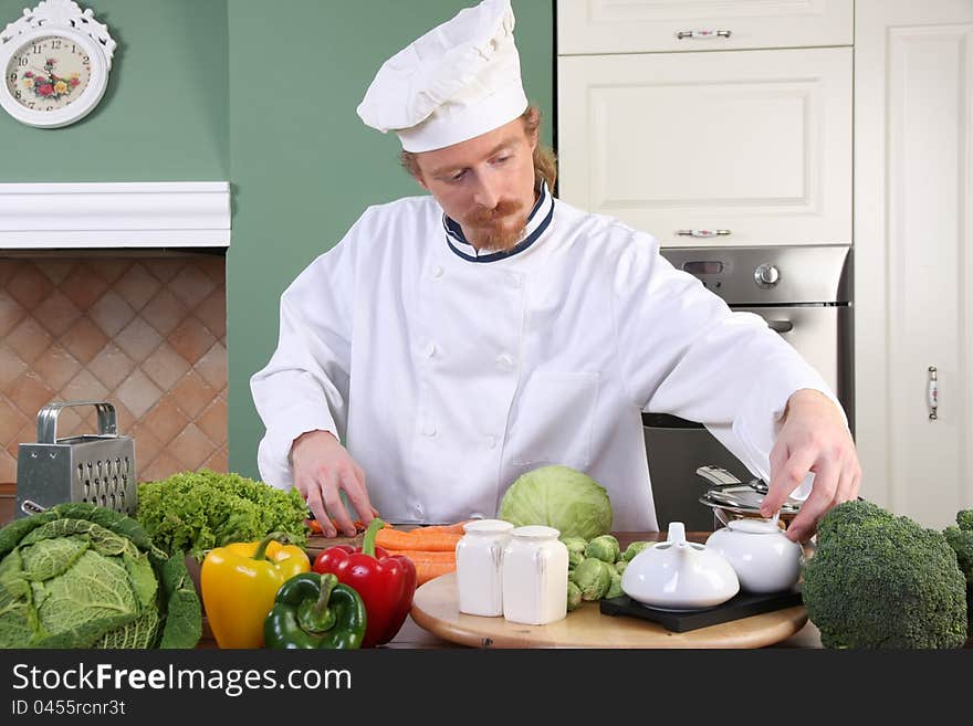 Young chef with vegetables, preparing lunch in kitchen. Young chef with vegetables, preparing lunch in kitchen