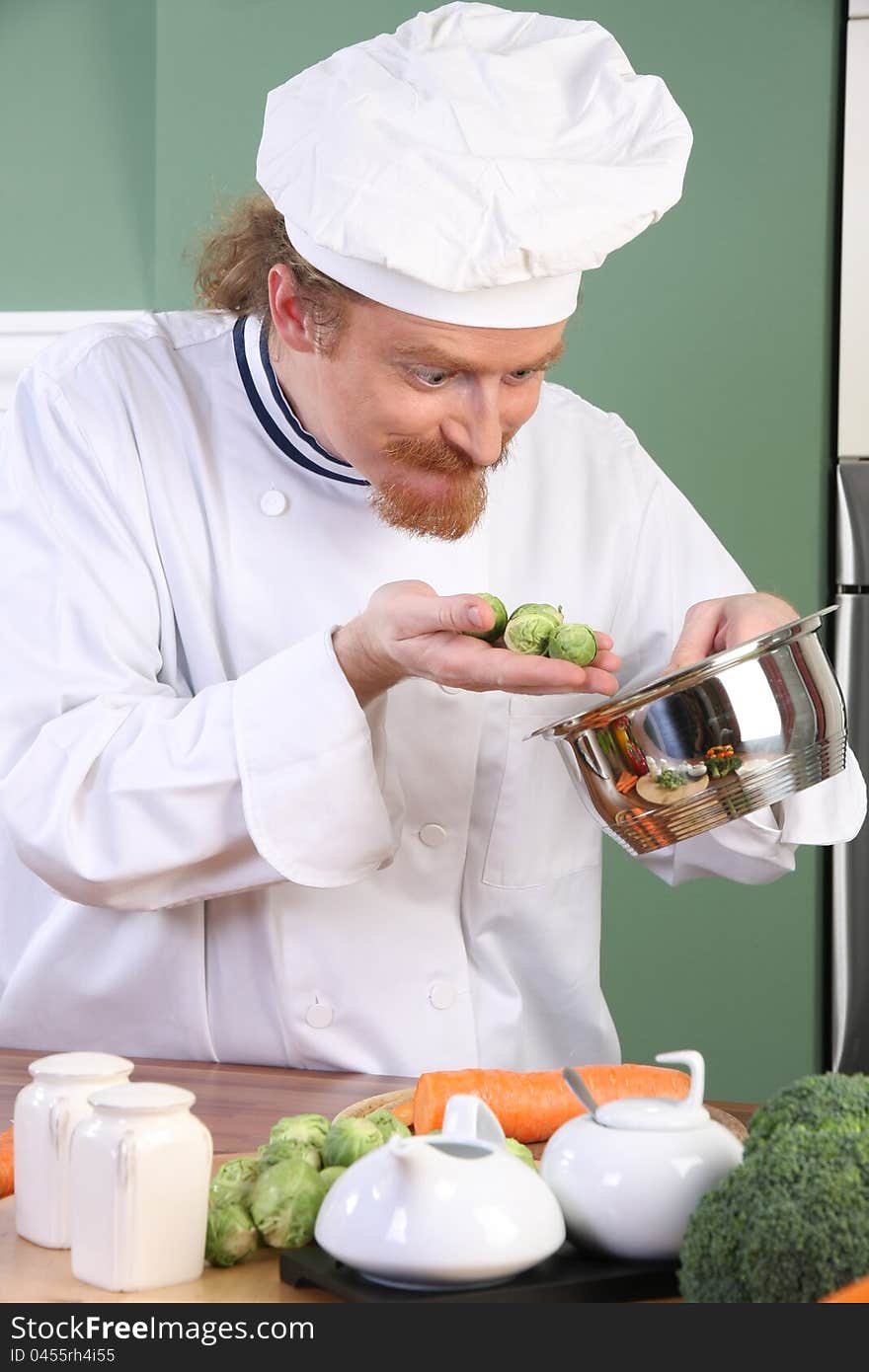 Funny young Chef with Brussels sprouts, preparing lunch in kitchen