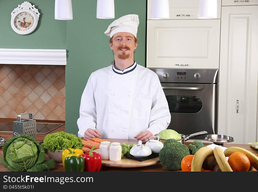 Young chef with vegetables, preparing lunch in kitchen. Young chef with vegetables, preparing lunch in kitchen