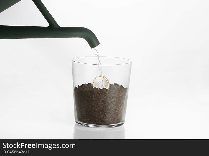 Seeding of a euro coin in a transparent glass. Seeding of a euro coin in a transparent glass