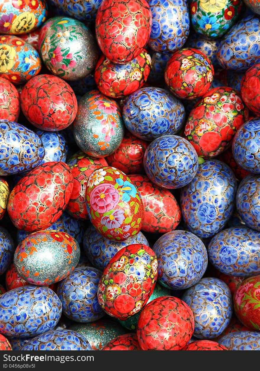 Artificial eggs coloured in different styles as background. Artificial eggs coloured in different styles as background.