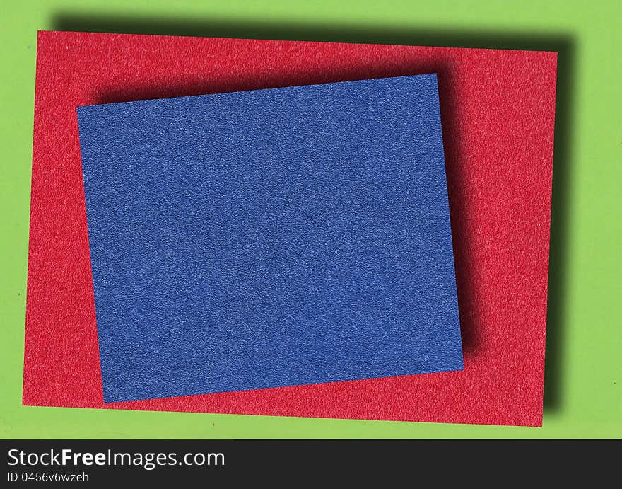 Red and blue abrasive paper on green background paper. Red and blue abrasive paper on green background paper