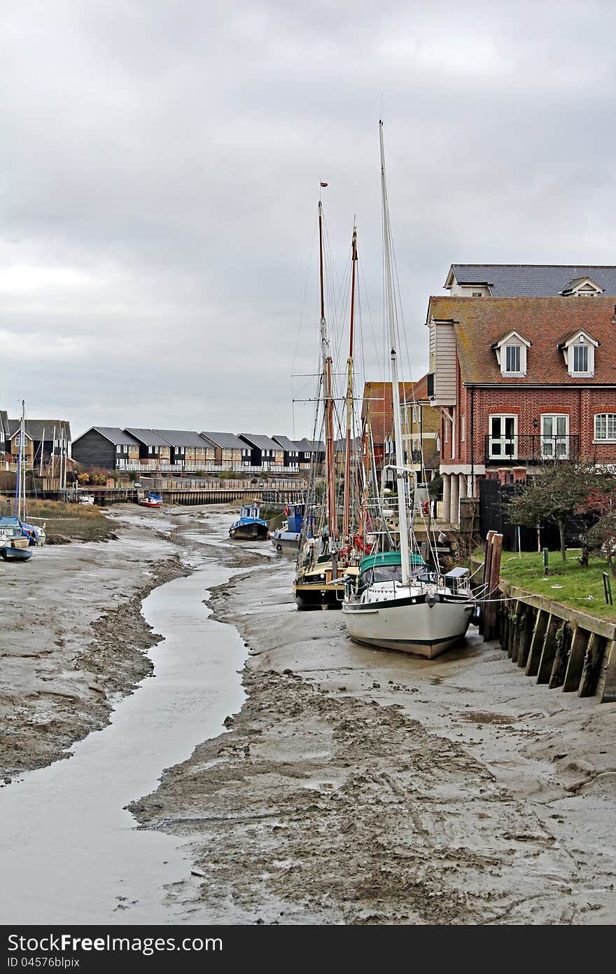 Photo of boats and yachts moored up on faversham creek at low tide. Photo of boats and yachts moored up on faversham creek at low tide.