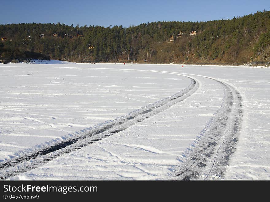 Car tracks on a frozen lake turning to the left