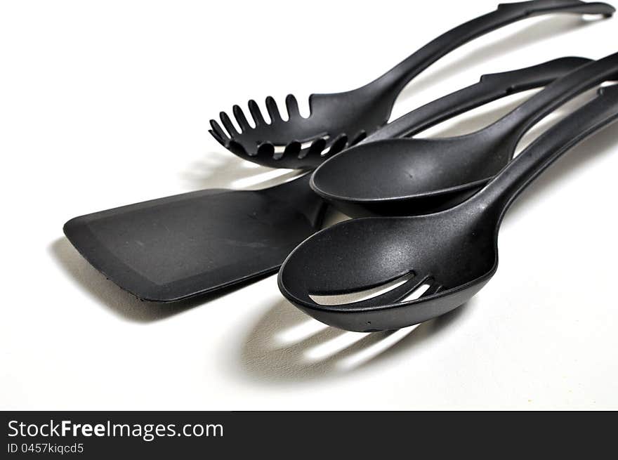 Four cooking utensil's are siting on a white background. A spatula, slotted spoon, a pasta spoon and a serving spoon. Four cooking utensil's are siting on a white background. A spatula, slotted spoon, a pasta spoon and a serving spoon.