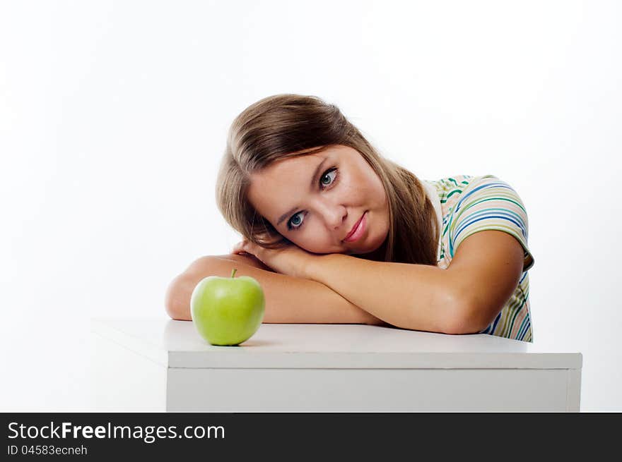 Young woman looking at apple in front of her