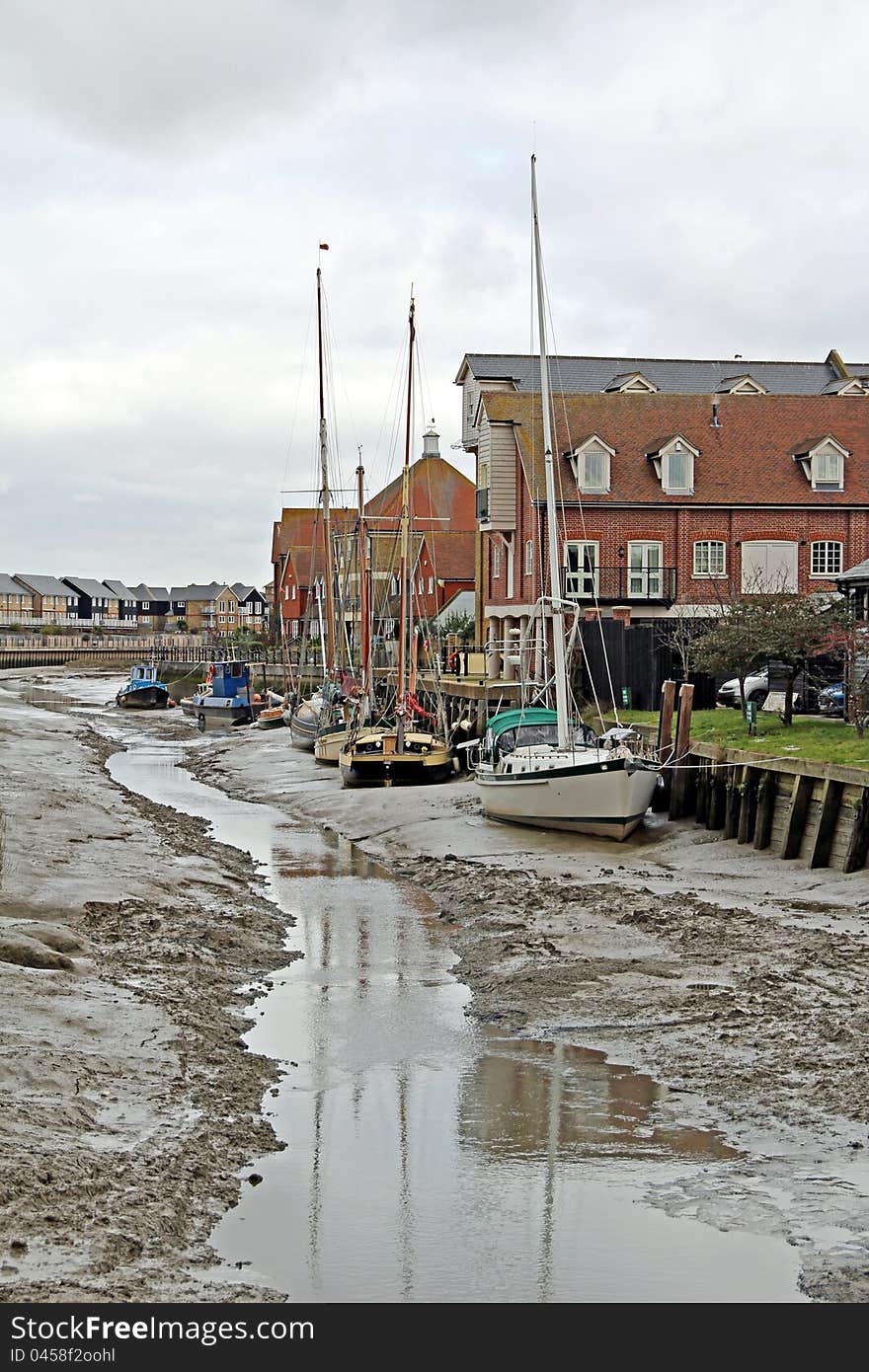 Photo of boats and yachts moored up on faversham creek at low tide. Photo of boats and yachts moored up on faversham creek at low tide.