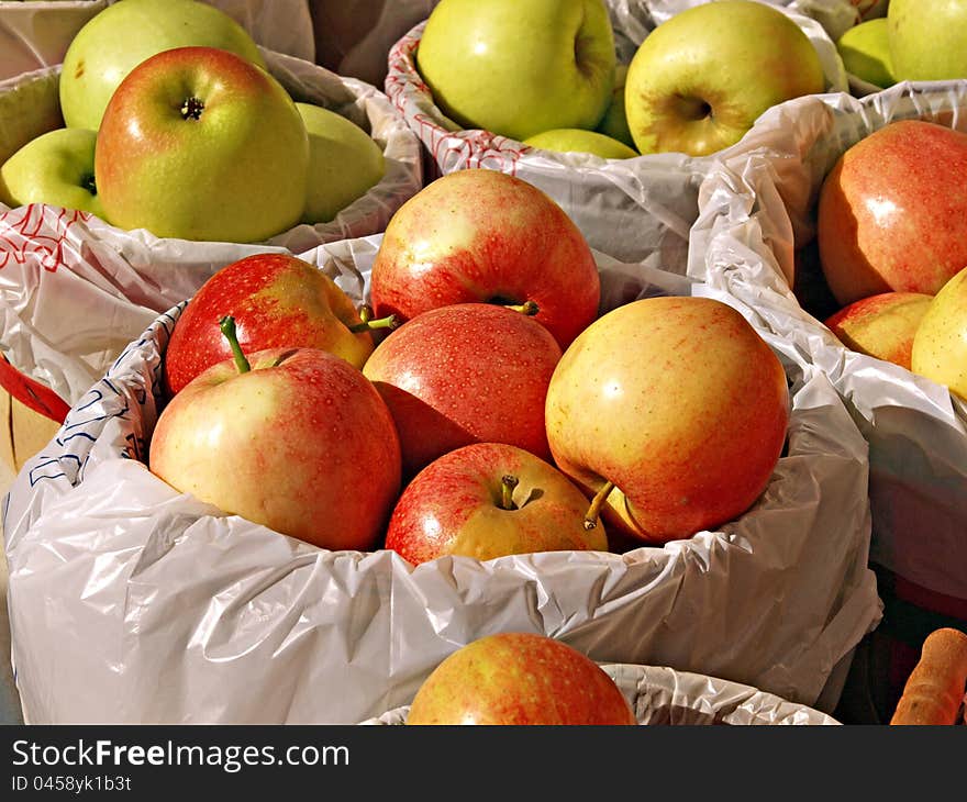 Close ups of baskets of freshly picked apples, stacked on a table top at an outside farmers market in the fall. Close ups of baskets of freshly picked apples, stacked on a table top at an outside farmers market in the fall.