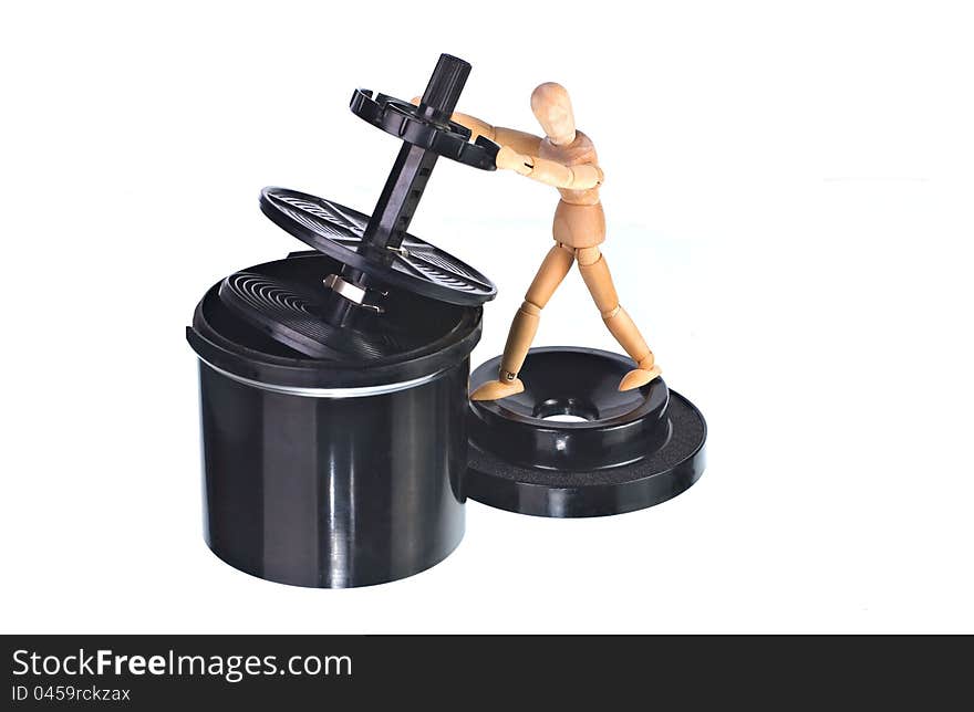 A black black plastic roll film developing tank with art doll isolated on white. A black black plastic roll film developing tank with art doll isolated on white