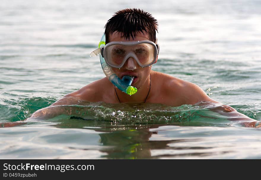 The man in the sea in a mask with a tube