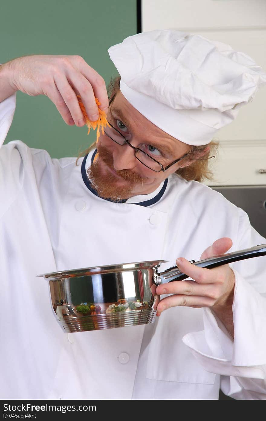 Funny young chef add carrots in the pot