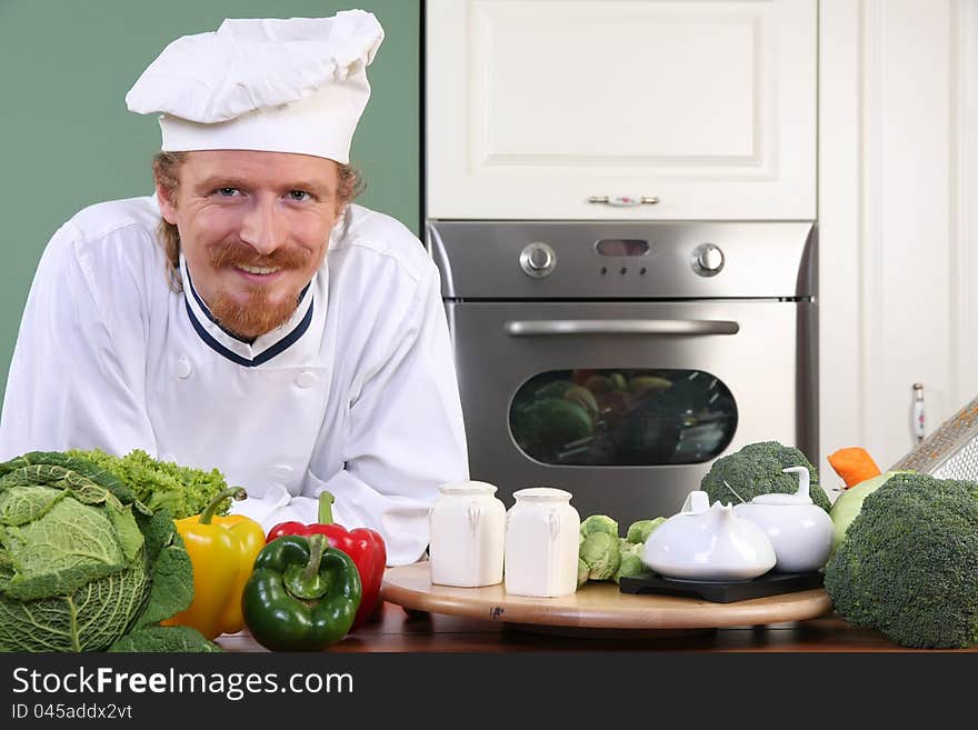 Young chef with vegetables, preparing lunch in kitchen. Young chef with vegetables, preparing lunch in kitchen