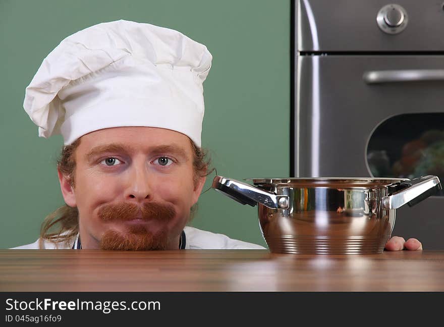 Funny young chef with a pot