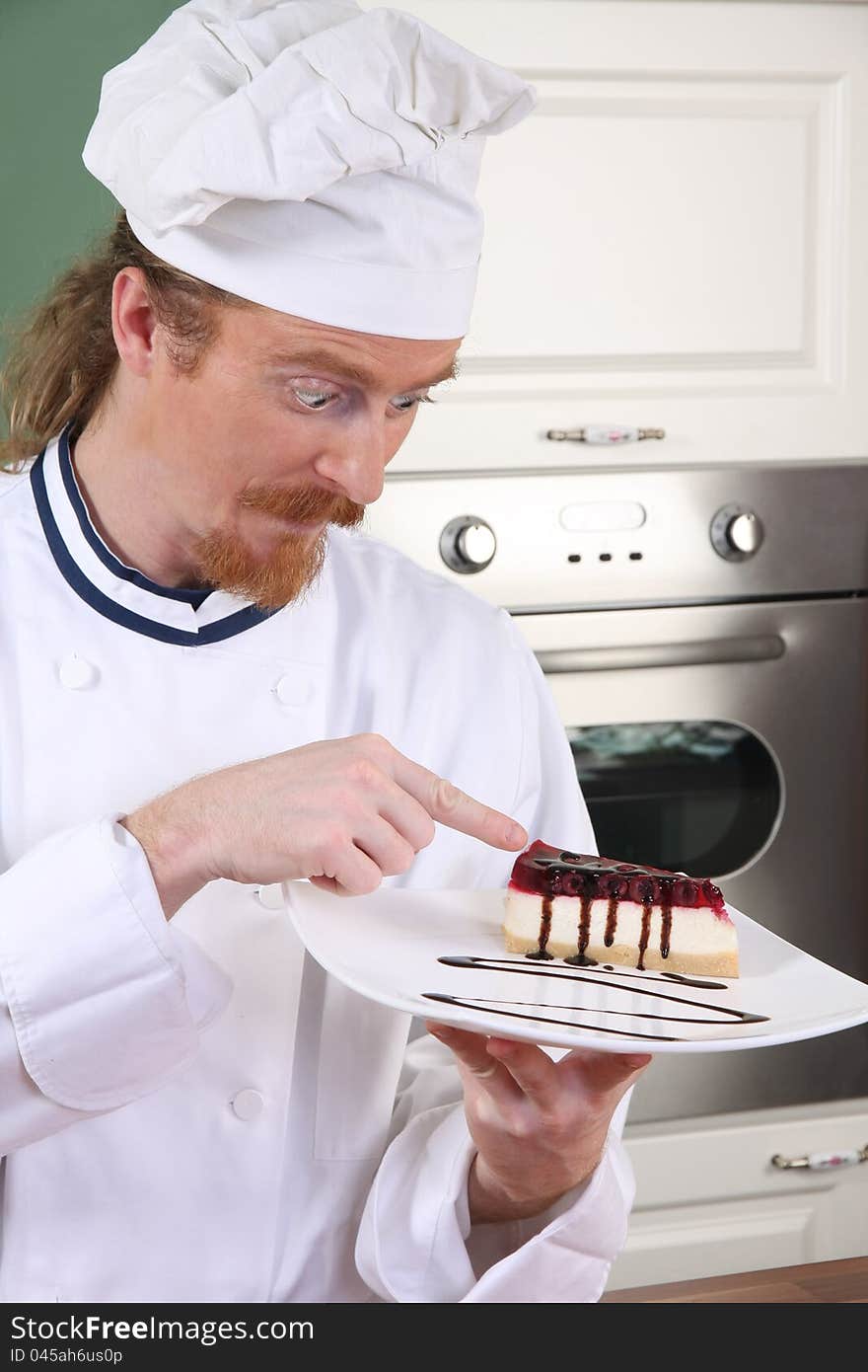 Funny young chef strange looking at piece of cake with chocolate sauce