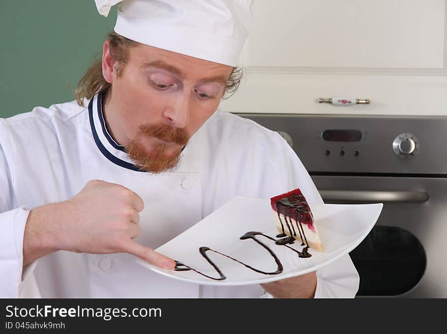 Funny young chef strange looking at piece of cake with chocolate sauce