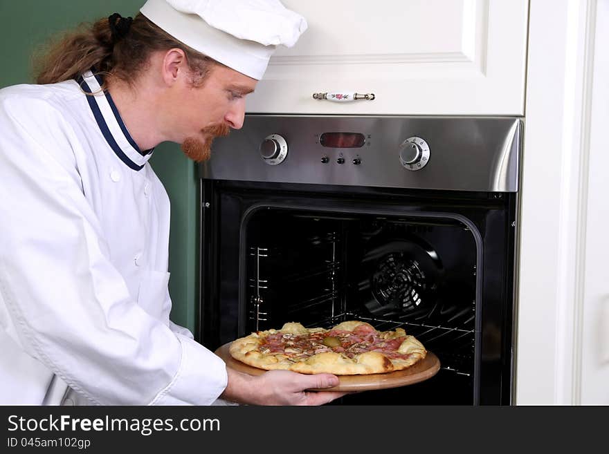 Young chef prepared italian pizza in kitchen