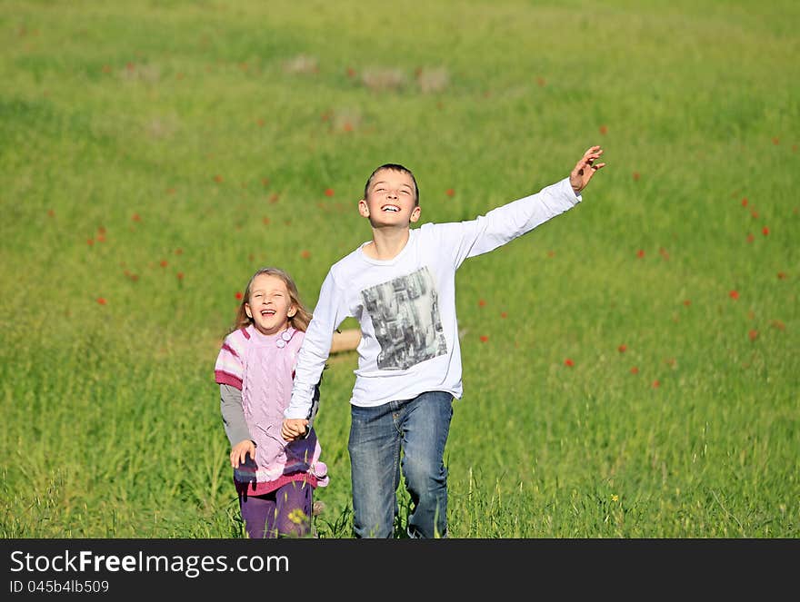 Brother and sister, laughing and running around on the grass. Brother and sister, laughing and running around on the grass