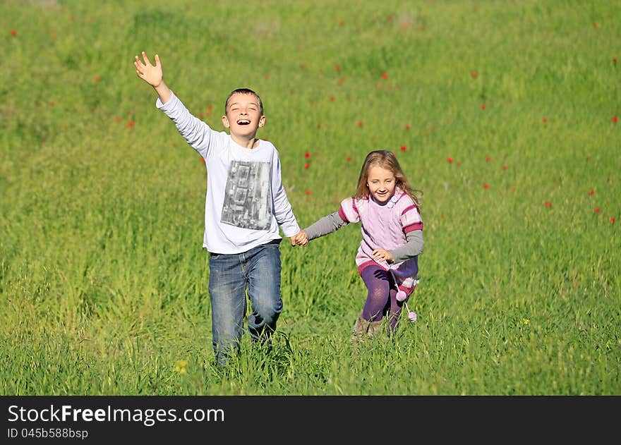 Brother and sister running around having fun outdoors in the summer