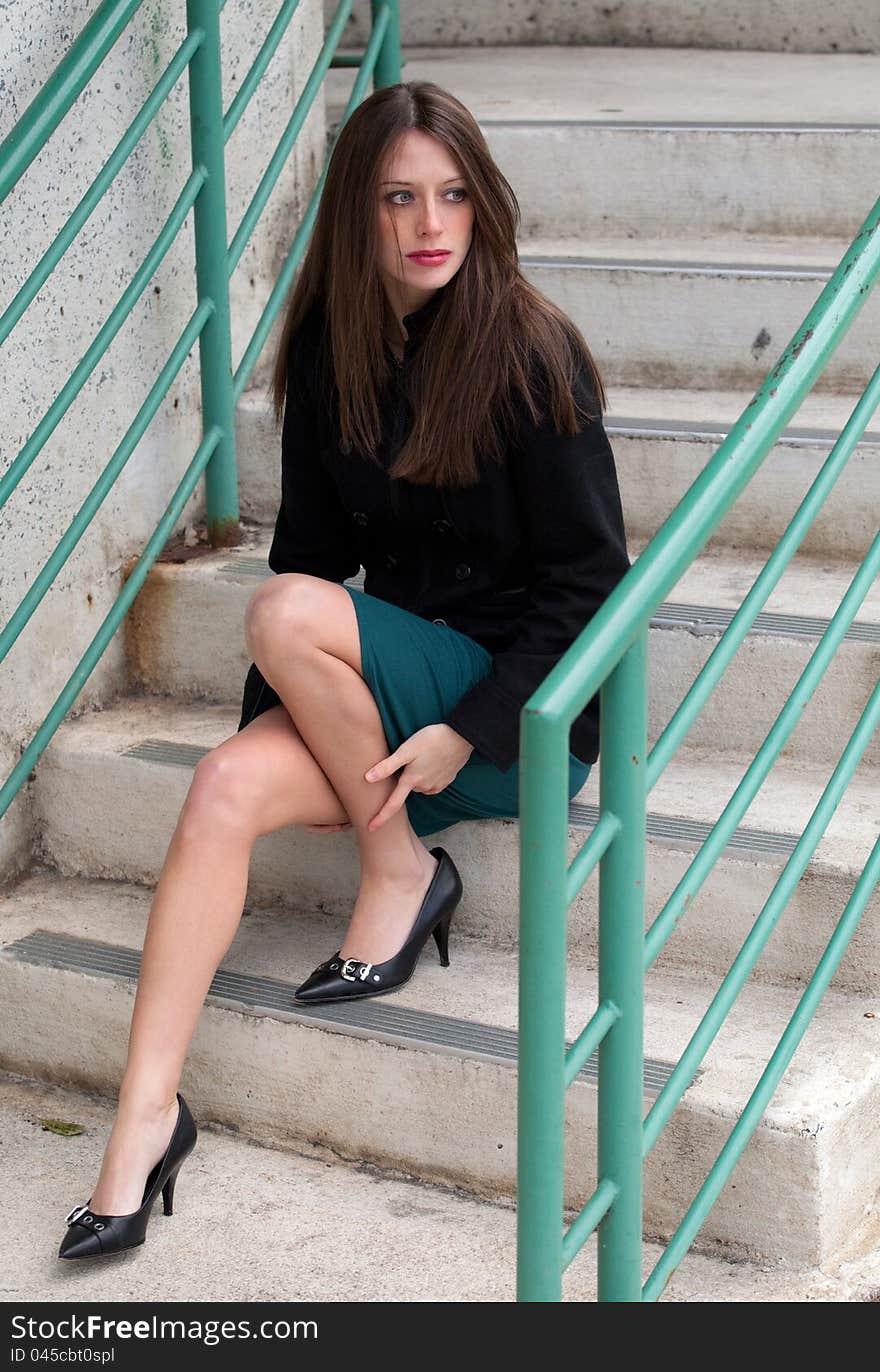 A portrait of a gorgeous, elegant woman in a jacket, skirt, and heels on an urban stairway. A portrait of a gorgeous, elegant woman in a jacket, skirt, and heels on an urban stairway