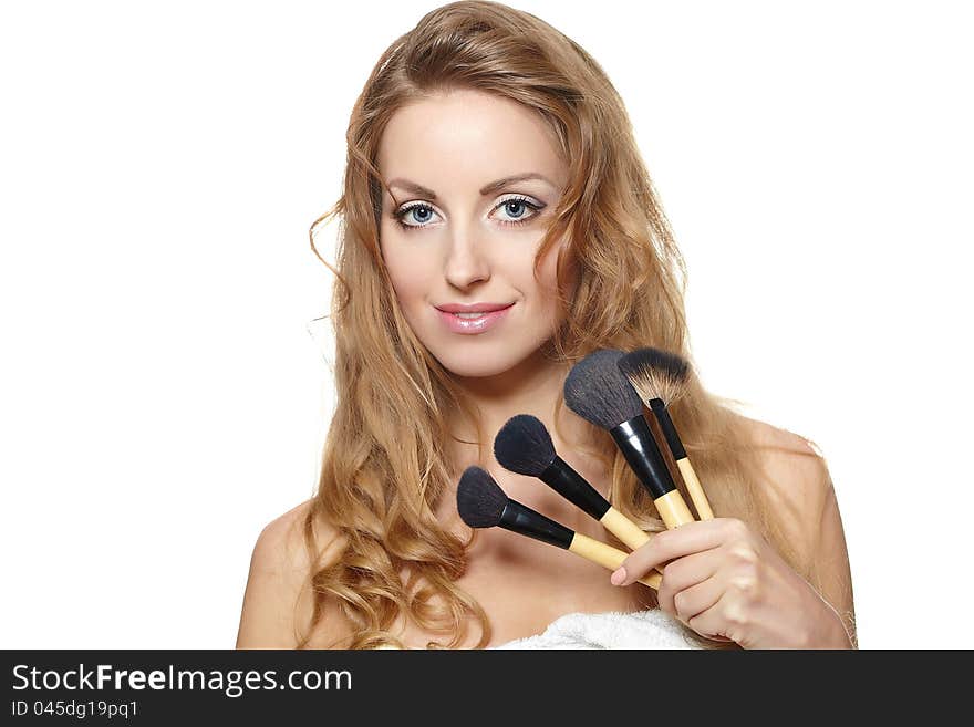 Beautiful woman with makeup brushes