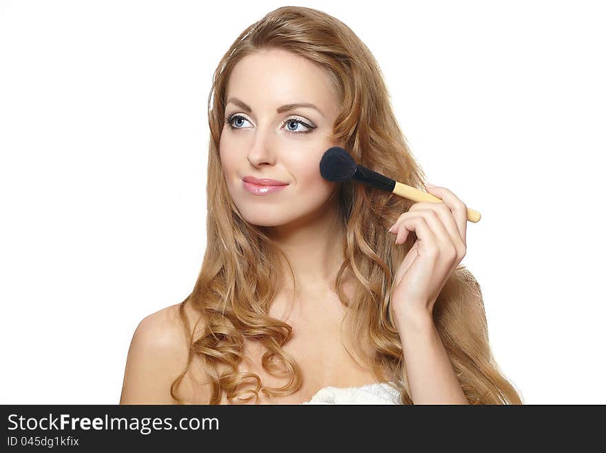 Close-up portrait of young beautiful woman applying makeup, isolated on white background