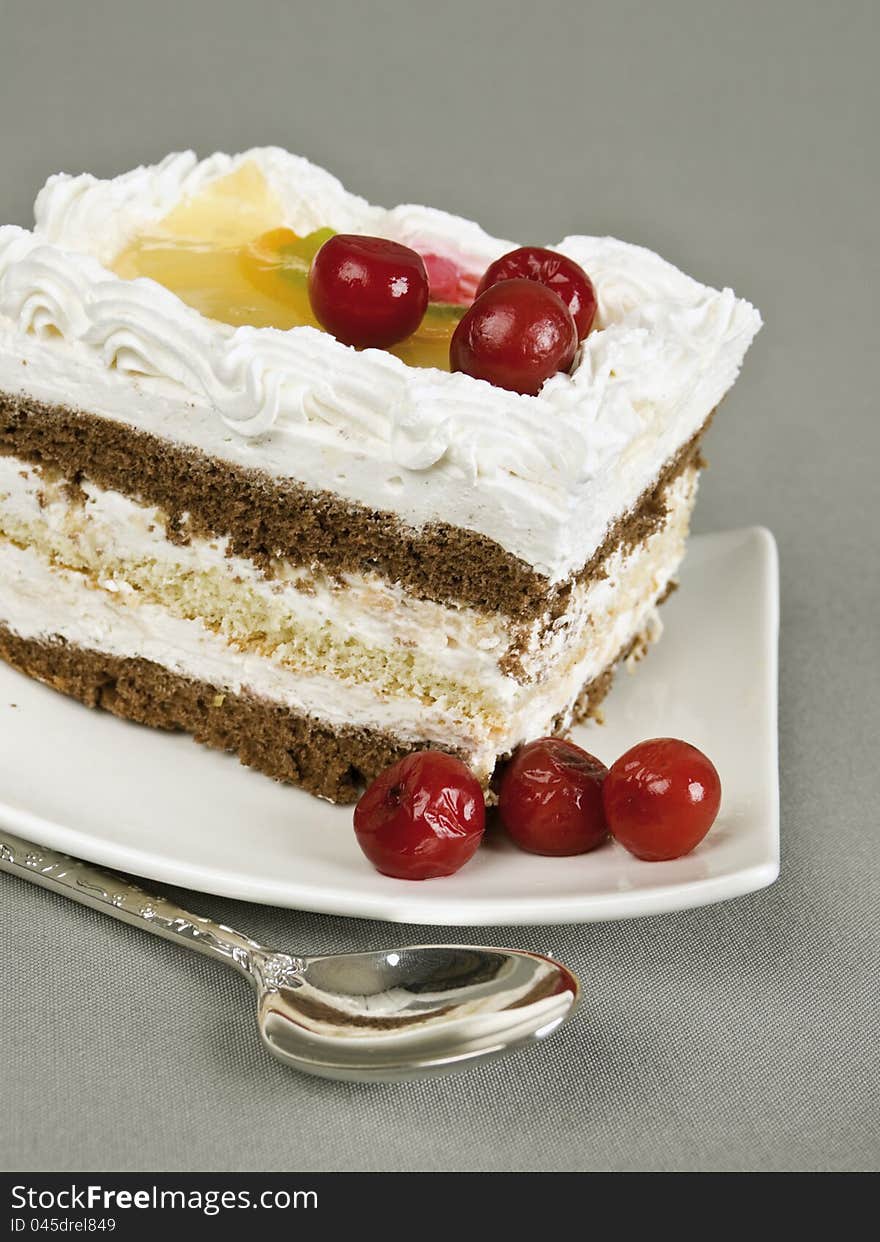 Cake lies on a saucer and tea spoon