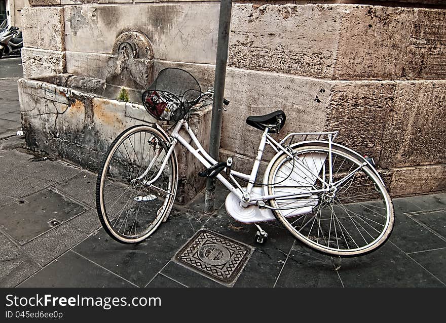 A lone bicycle thrown on the street. Rome. Italy.