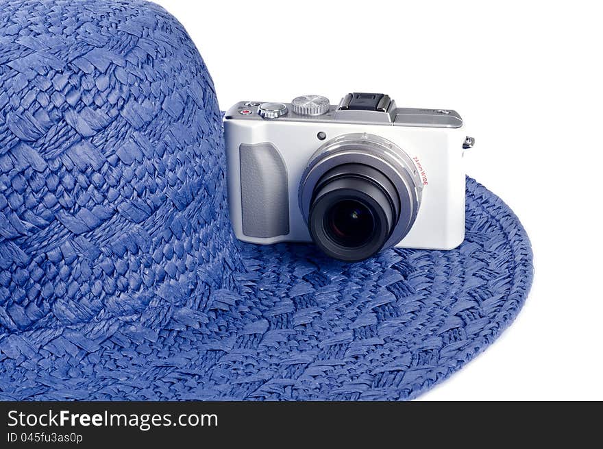 A blue straw hat and a white digital camera. A blue straw hat and a white digital camera.