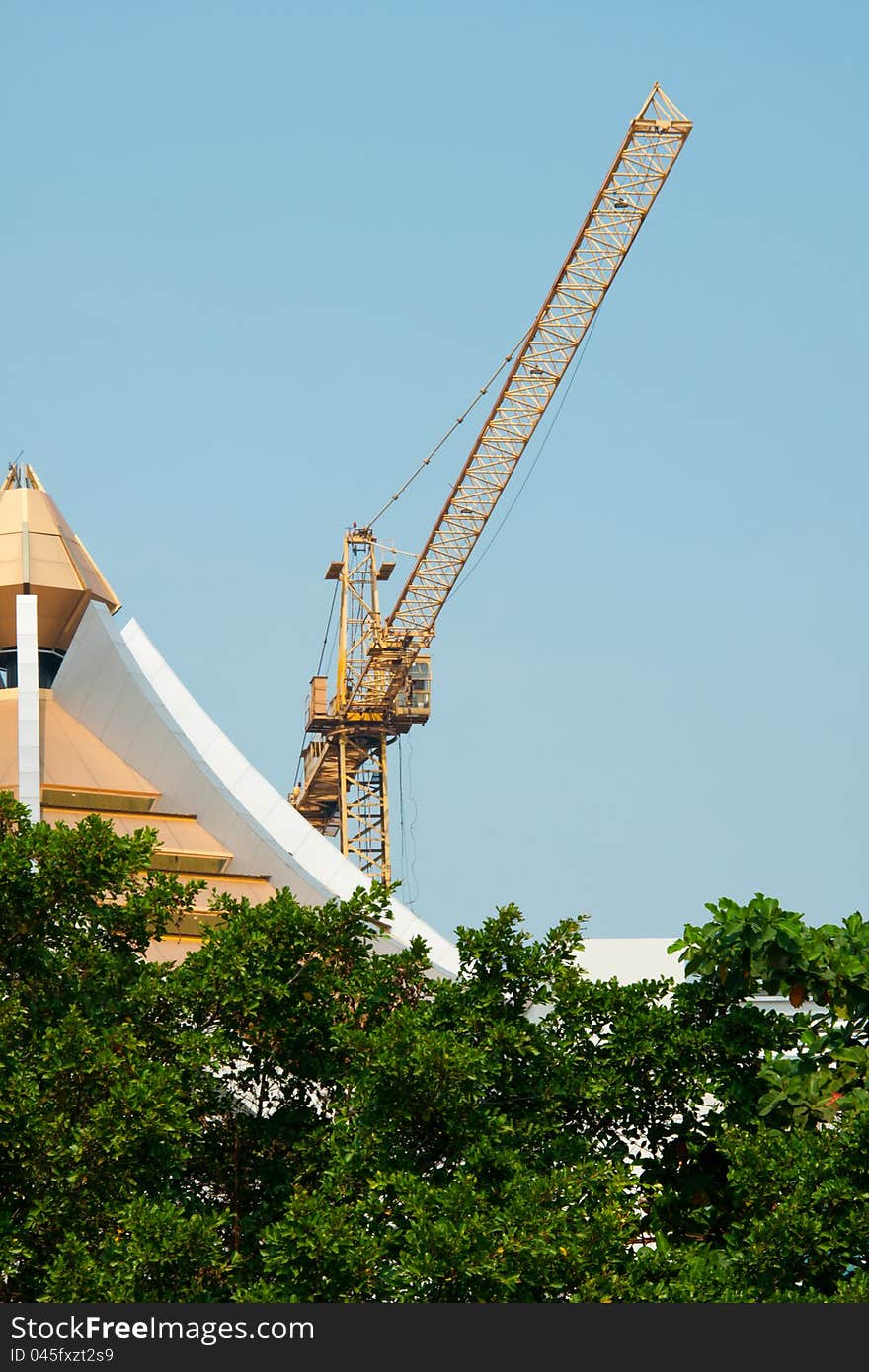 Ellow tower crane against clear blue sky. Ellow tower crane against clear blue sky