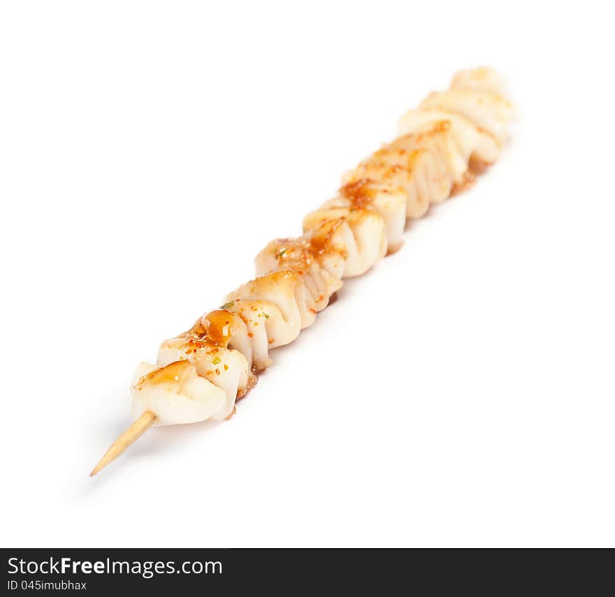 Skewered squid on wooden sticks grilled on white background