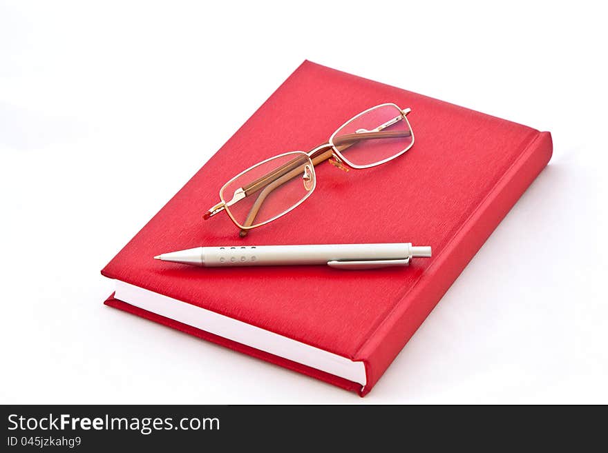 Glasses and the pen on the book