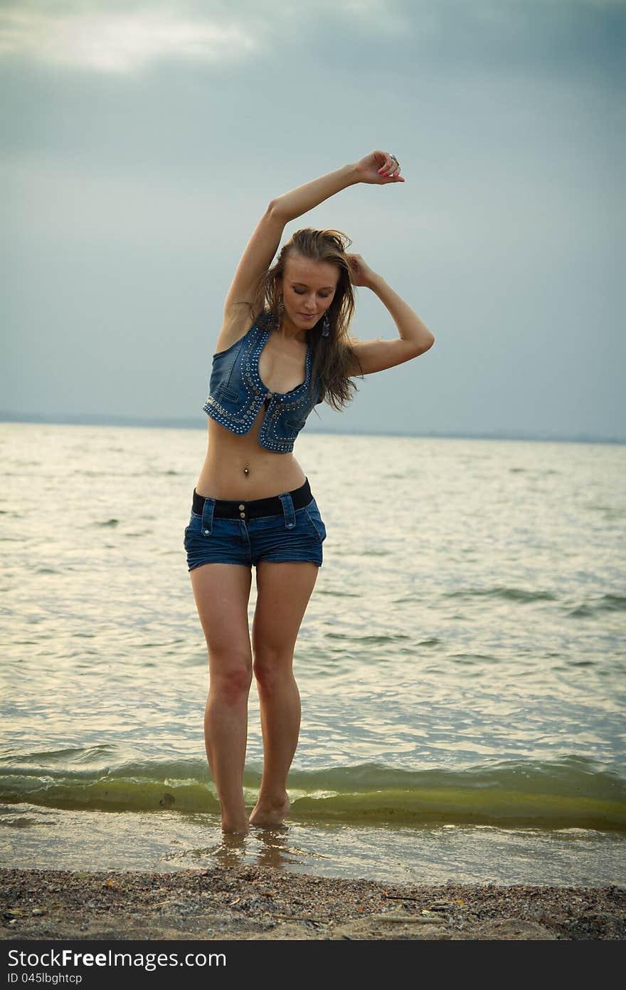 A girl on a deserted beach at sunset. A girl on a deserted beach at sunset