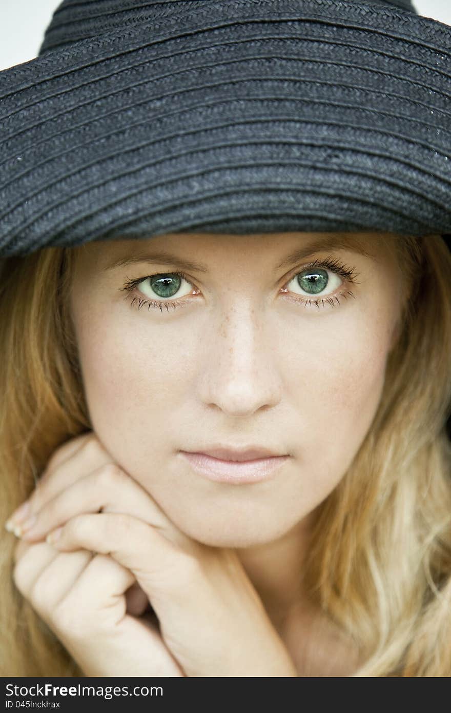 Portrait of a green-eyed girl in a hat