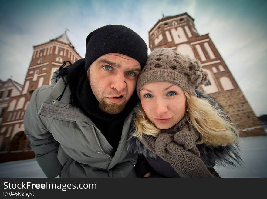 Traveling couple in love at the walls of the ancient castle