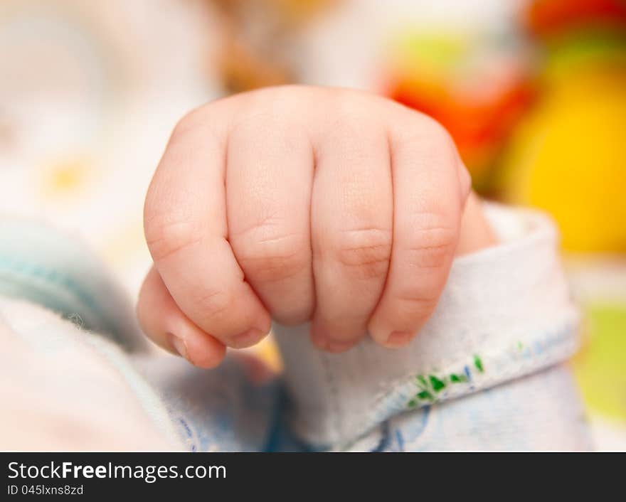 Baby's fist. Baby's hand on soft background. Baby's fist. Baby's hand on soft background