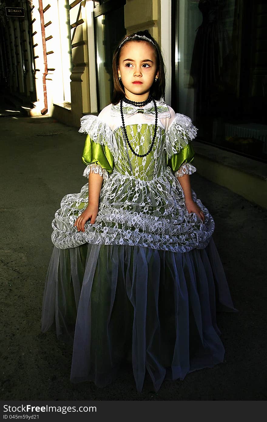 Girl dressed in vintage dress on old streets of the city