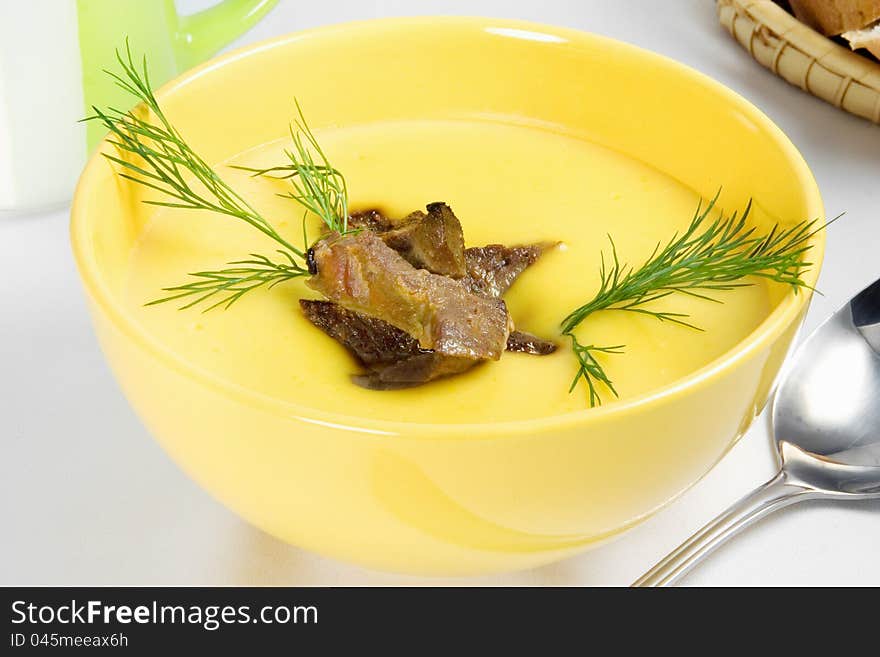 Yellow vegetable cream soup with meat