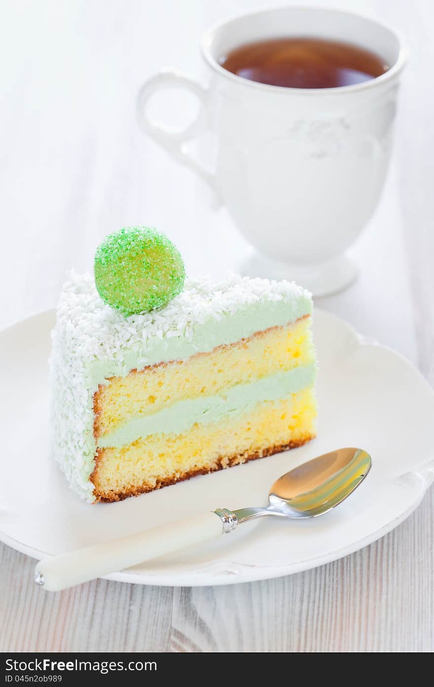 Saffron sponge cake with cream green tea, slice on a plate, selective focus. Saffron sponge cake with cream green tea, slice on a plate, selective focus