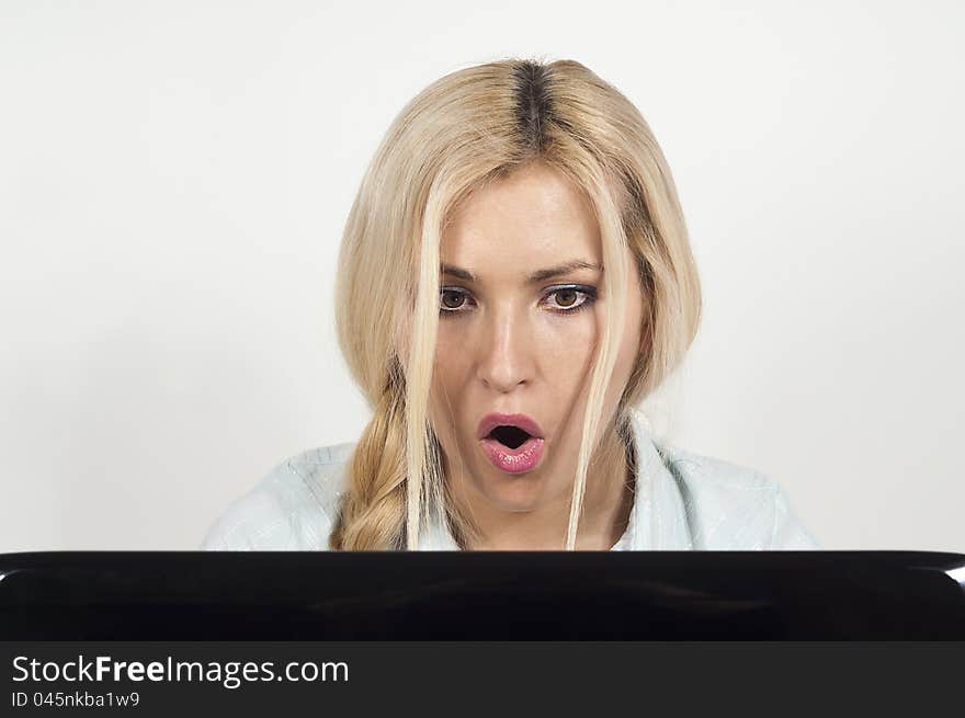 Beautiful girl sitting at a laptop and he was surprised at the background. Beautiful girl sitting at a laptop and he was surprised at the background