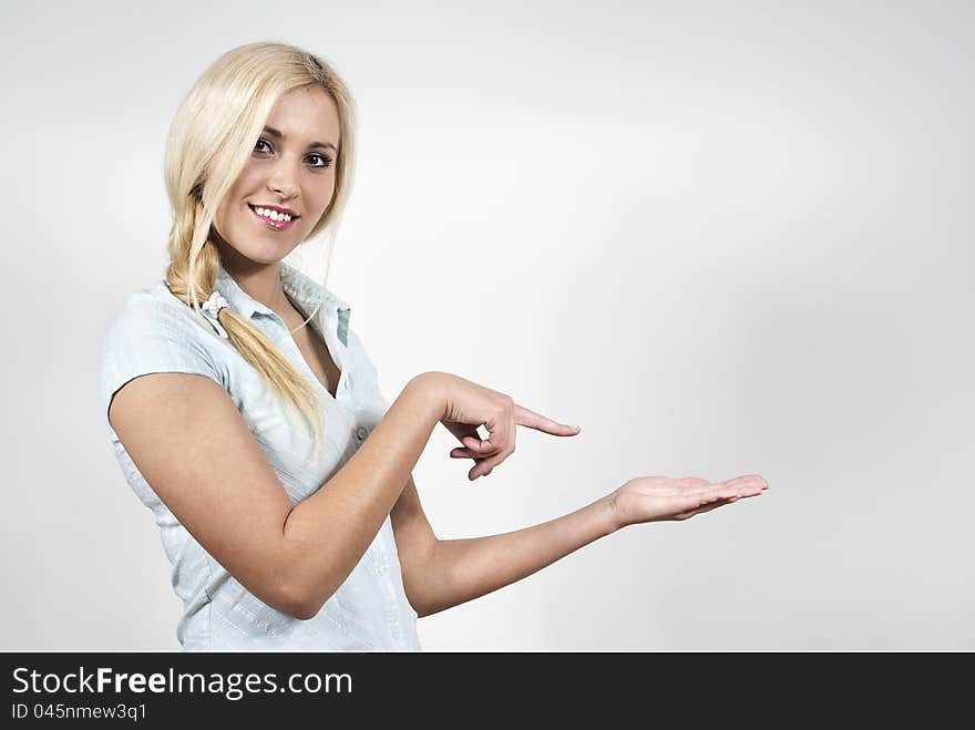 Happy beautiful girl indicates hand